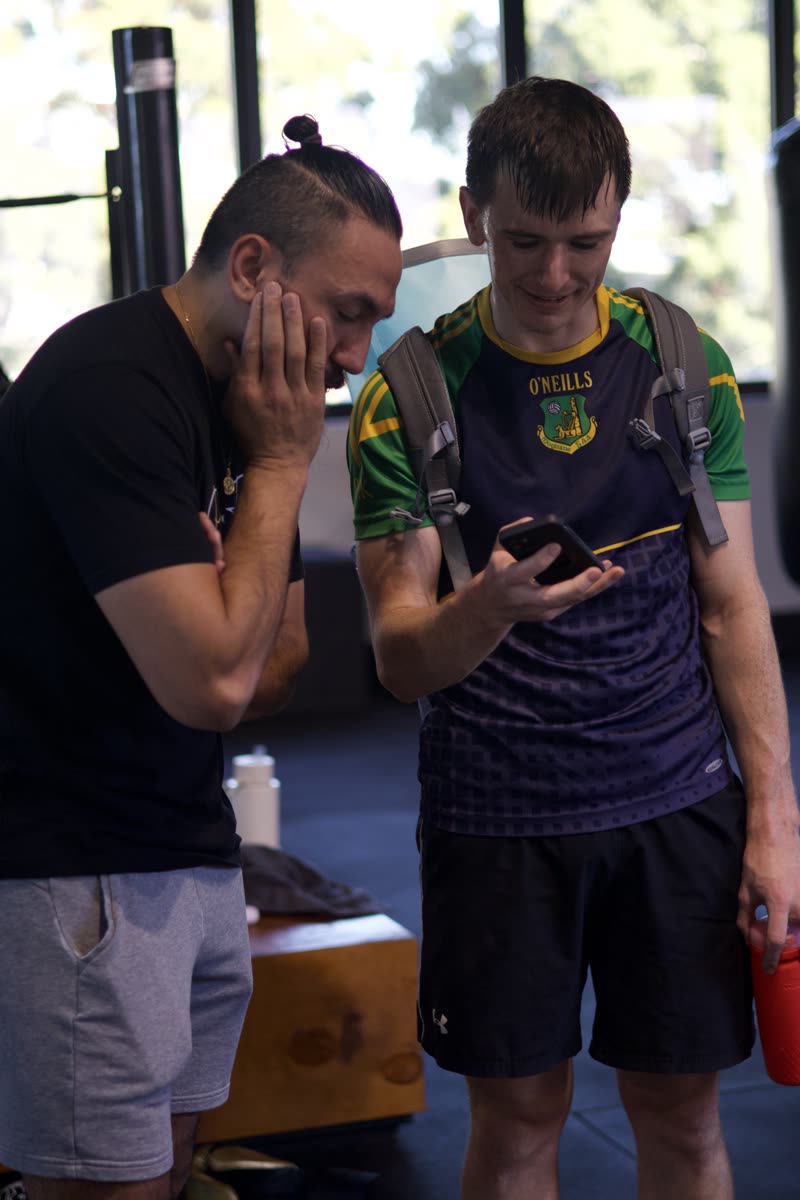 Coach and beginner looking at a phone before the first session
