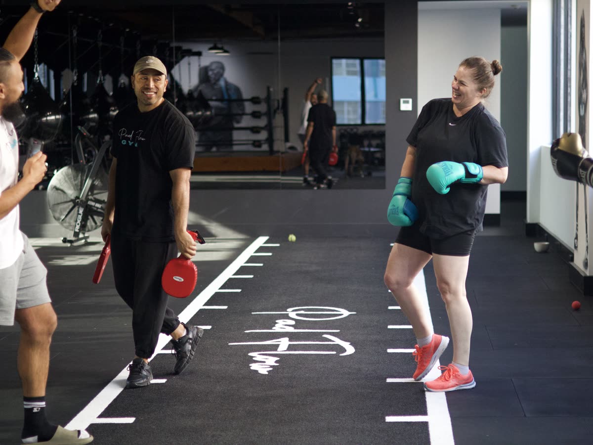Coach and member laughing on the gym floor